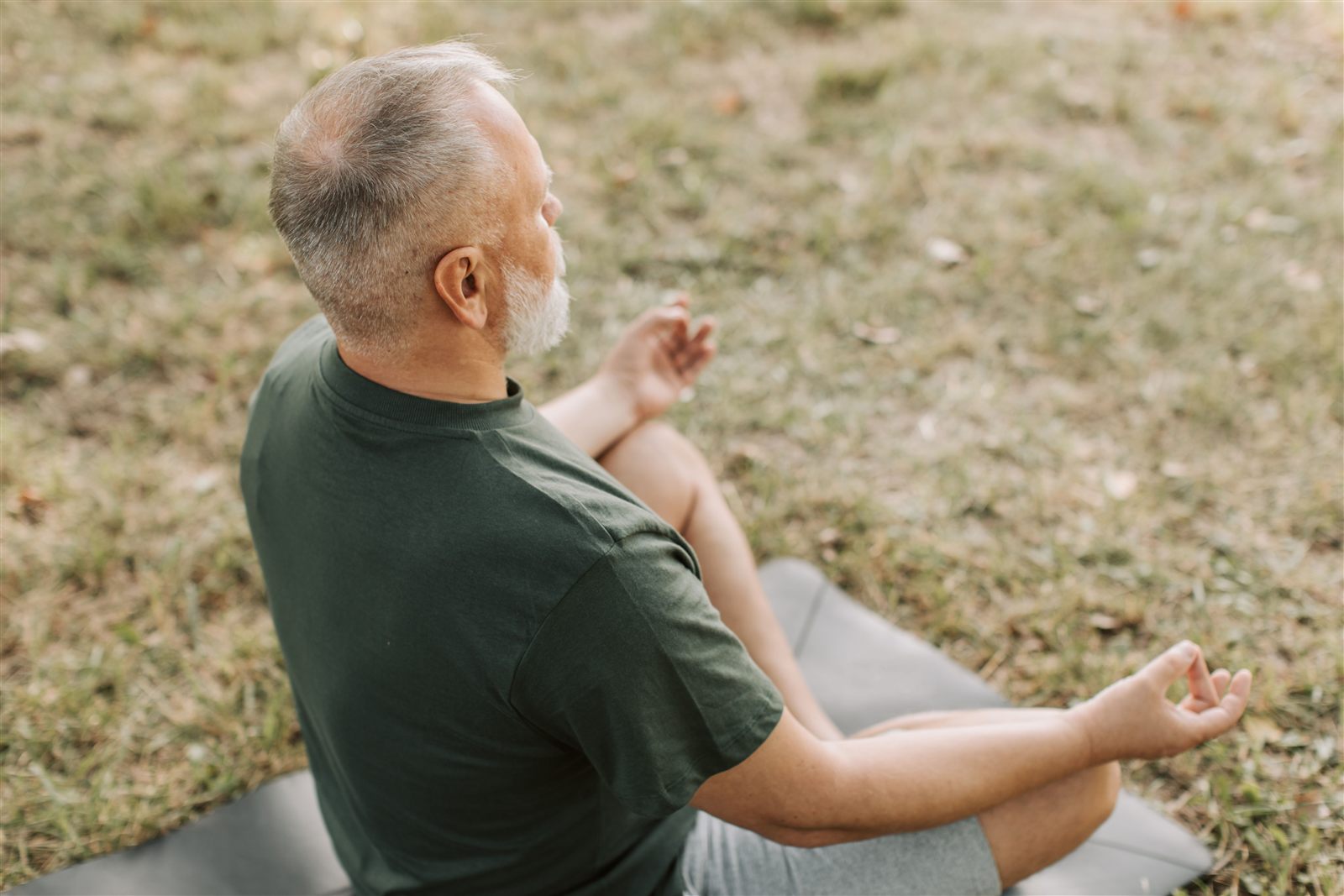 An older man meditating outdoors