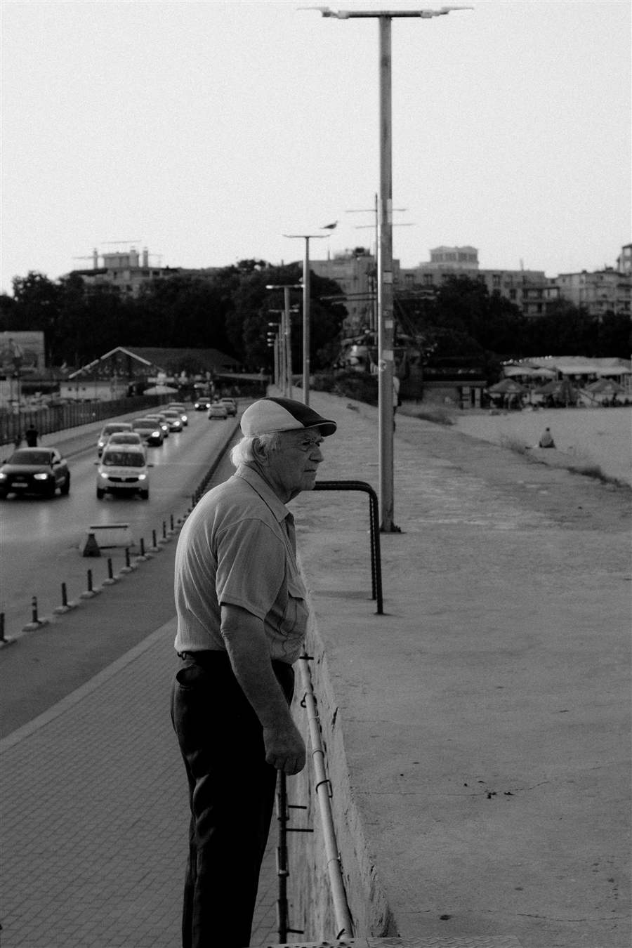 Senior man at a coastal waterfront, quietly observing — finding presence in the everyday